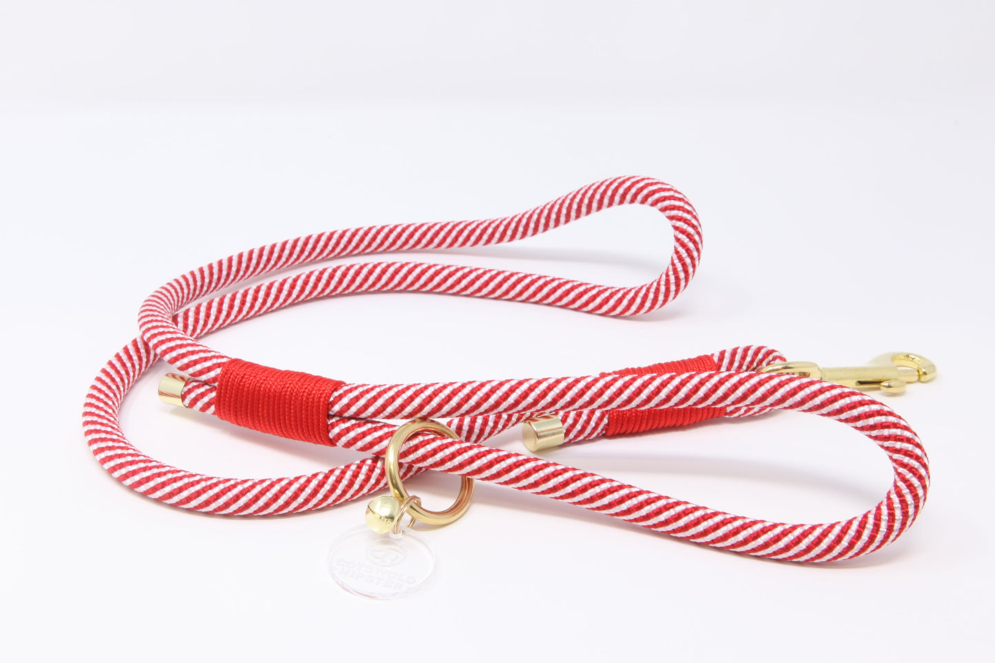 Red and white striped dog leash with brass trigger on a white background