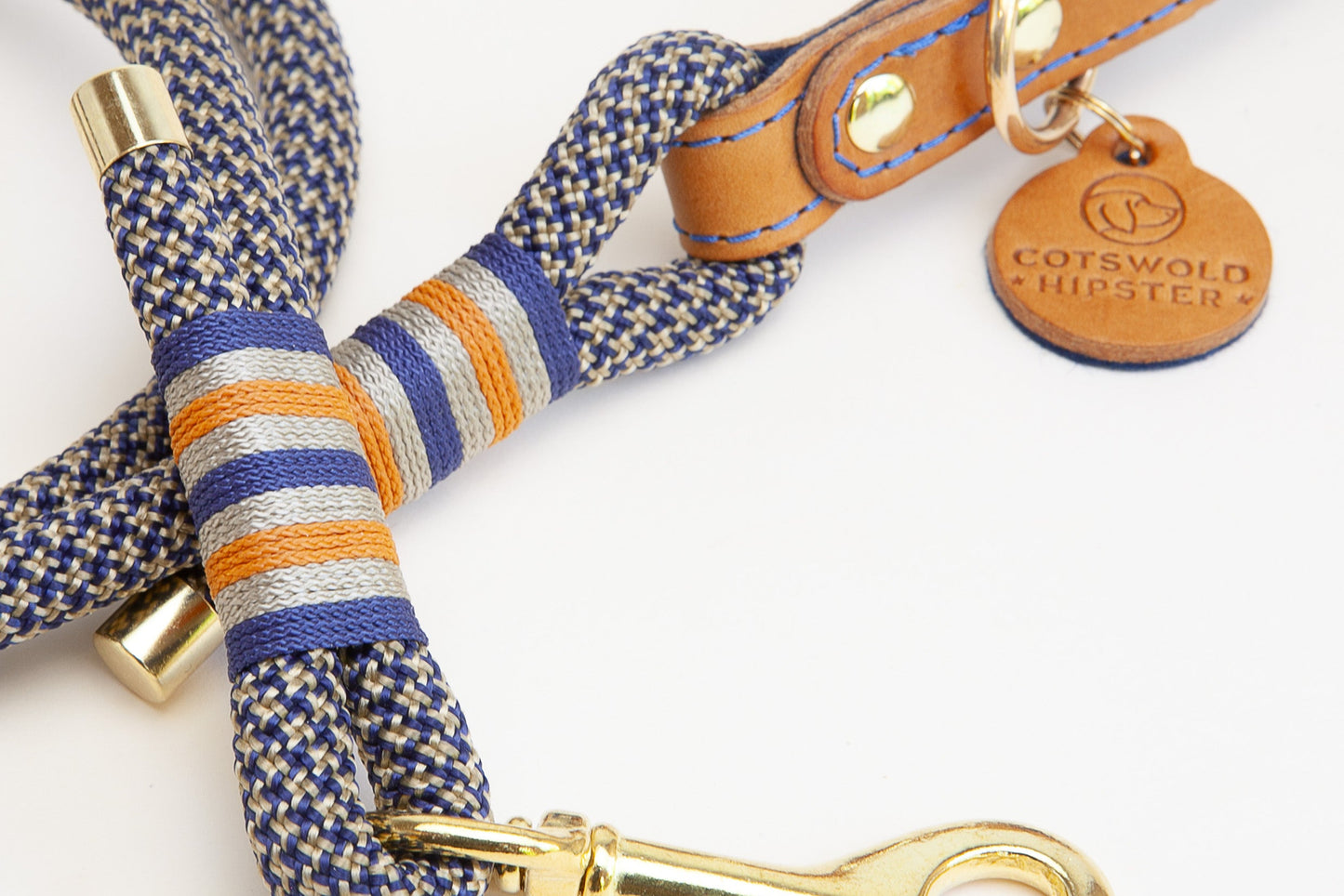 Close up of Tan and Marine rope dog lead with leather and felt handle, showing whipping detail and Cotswold Hipster tag, handmade with solid brass hardware