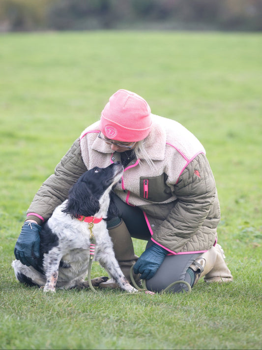 Person wearing a BE SEEN! Neon Pink beanie with dog wearing matching Neon Pink BioThane® collar and rope lead, high-visibility coordinated winter dog gear