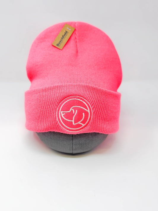 Neon pink unisex beanie with dog head logo on a mannequin head against a white background