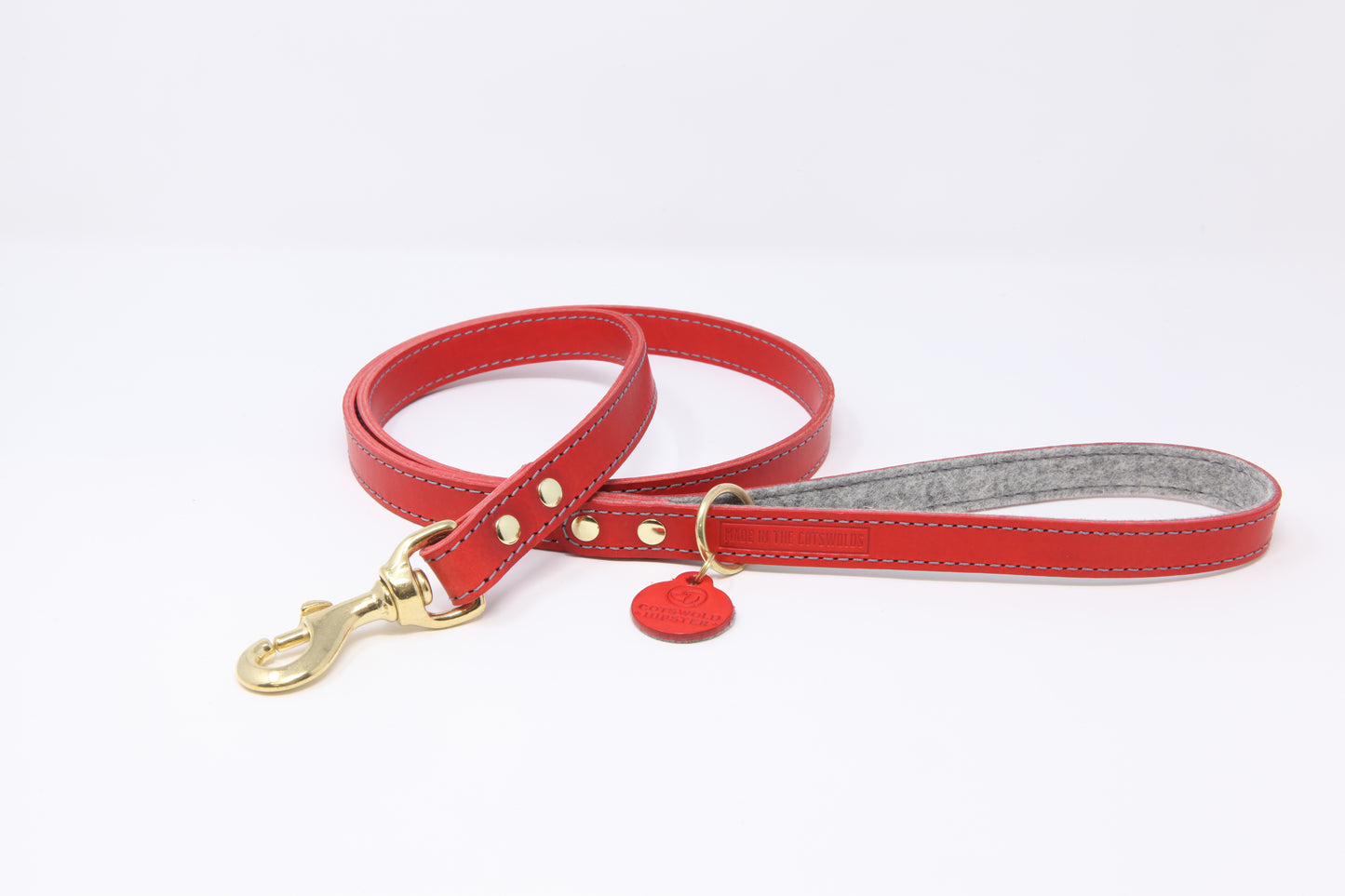 Red leather dog lead by Cotswold Hipster with grey contrast stitching, grey marl felt lining, and solid brass hardware