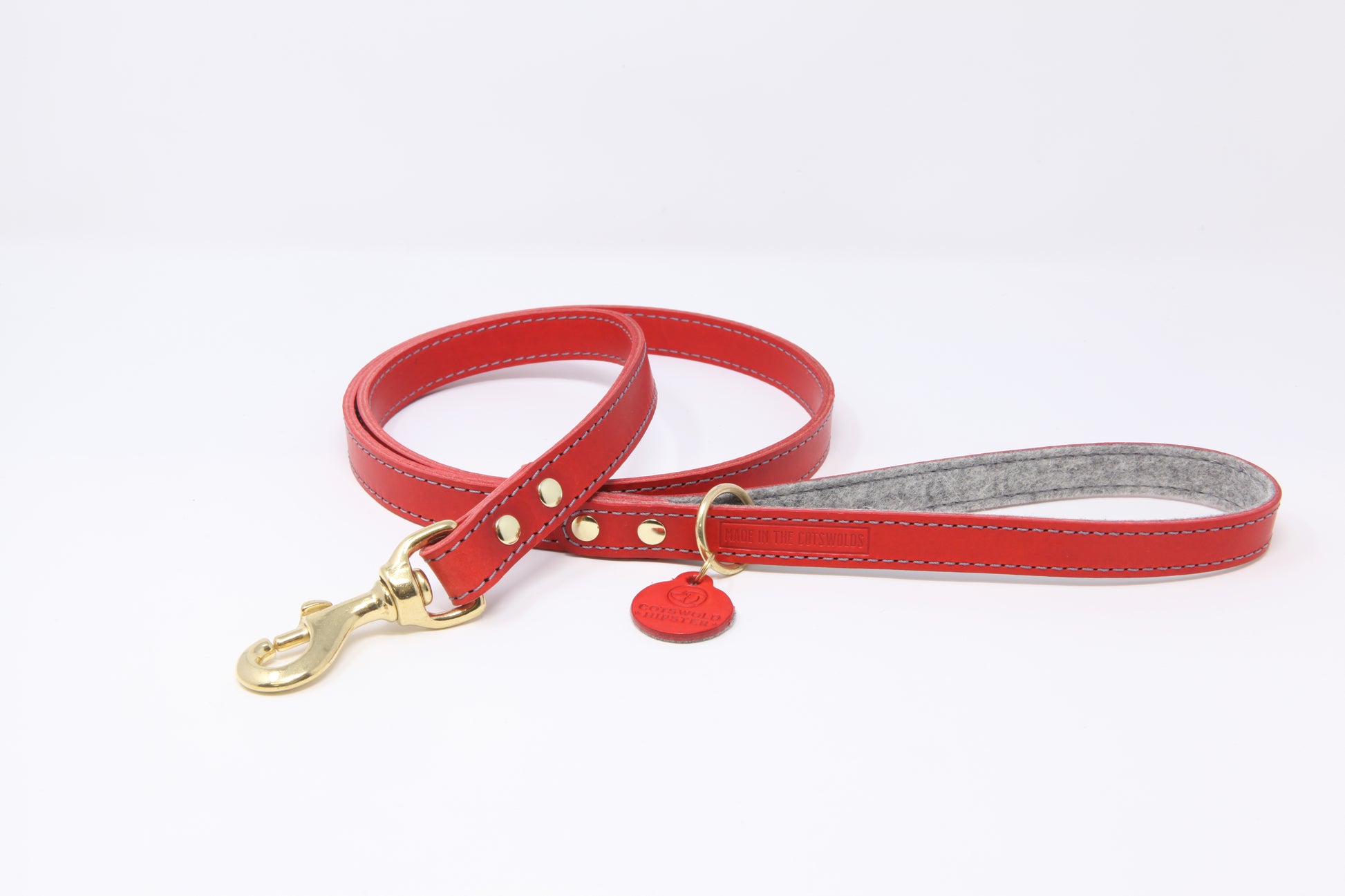 Red leather dog lead by Cotswold Hipster with grey contrast stitching, grey marl felt lining, and solid brass hardware