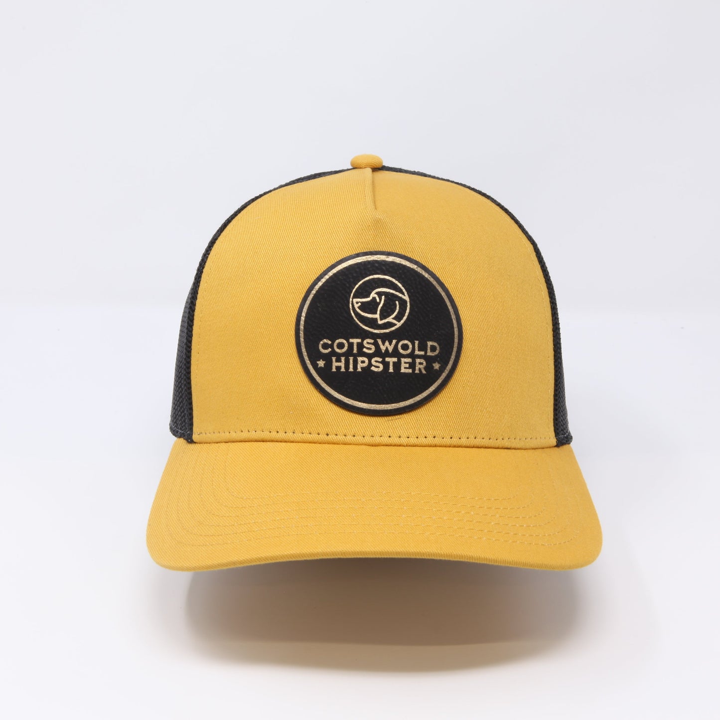 Front-facing mustard Field Cap on white background, displaying logo patch and adjustable snap-back.