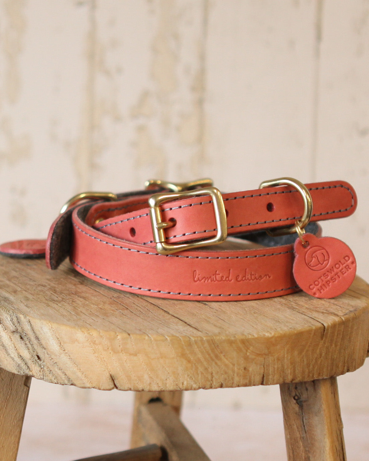 Close-up of the limited edition embossing on a coral and charcoal leather and felt dog collar.