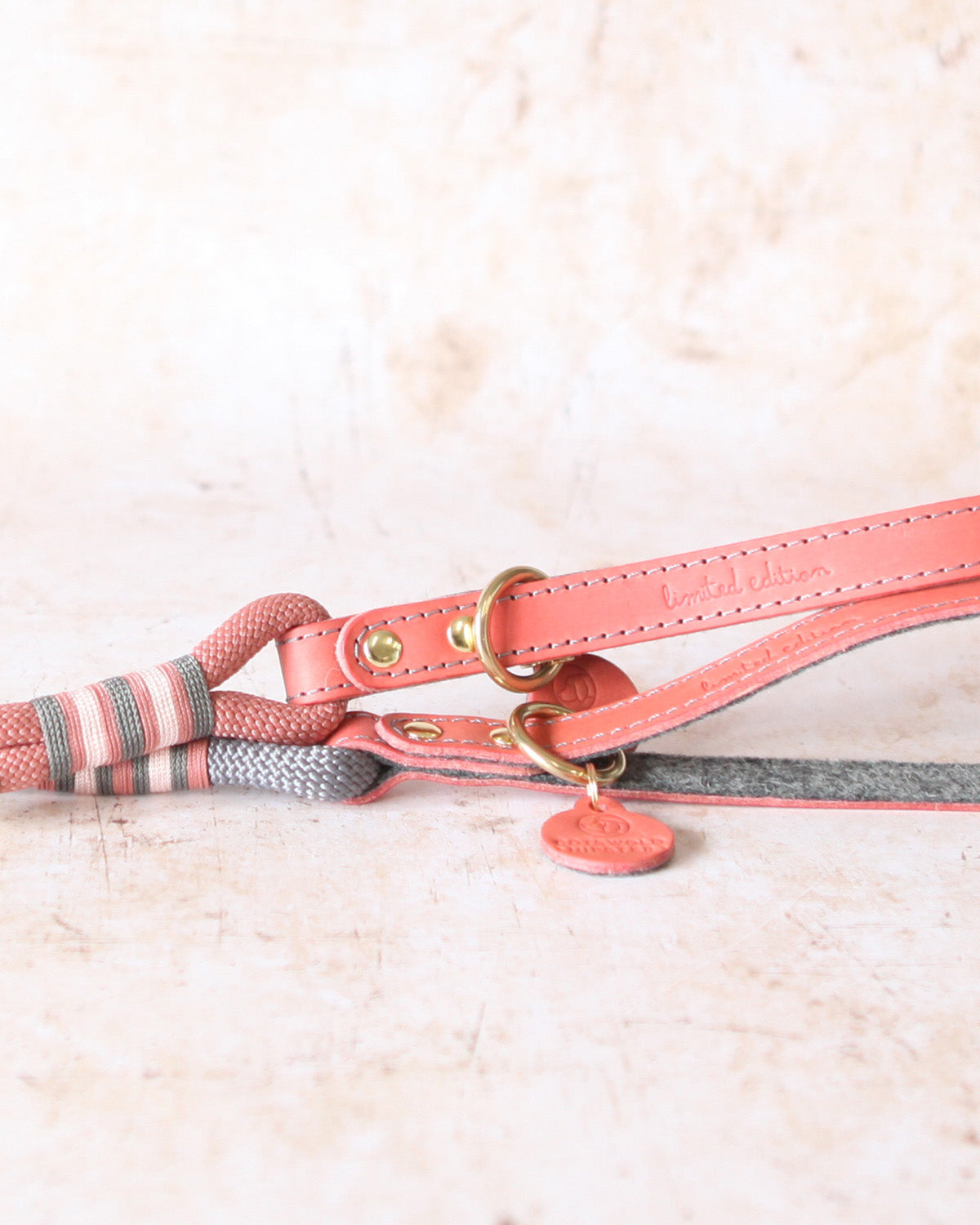 Close-up of the leather handle and solid brass fittings on a Coral & Charcoal Limited Edition rope dog lead.