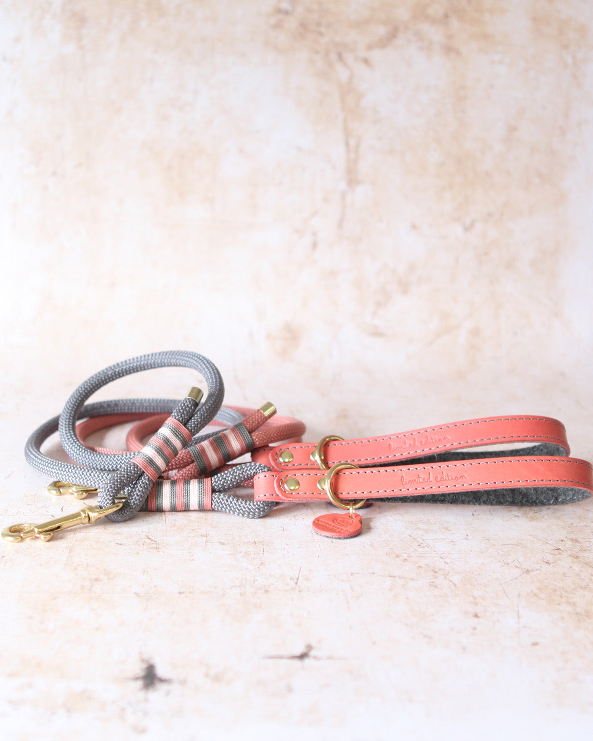 Coral and charcoal limited edition leather and rope dog leads shown together.