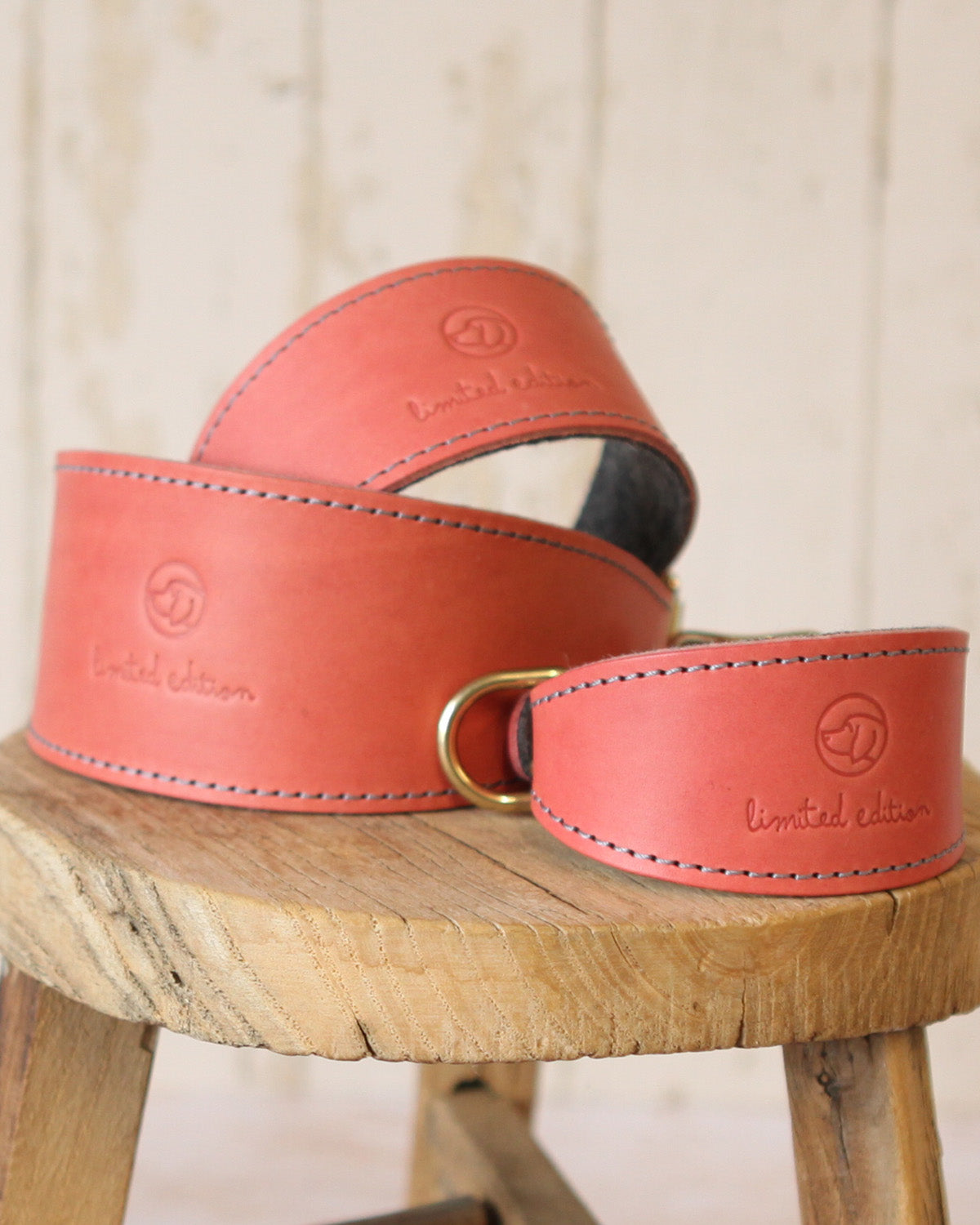 Coral and charcoal limited edition leather and felt sighthound collars shown in three sizes.