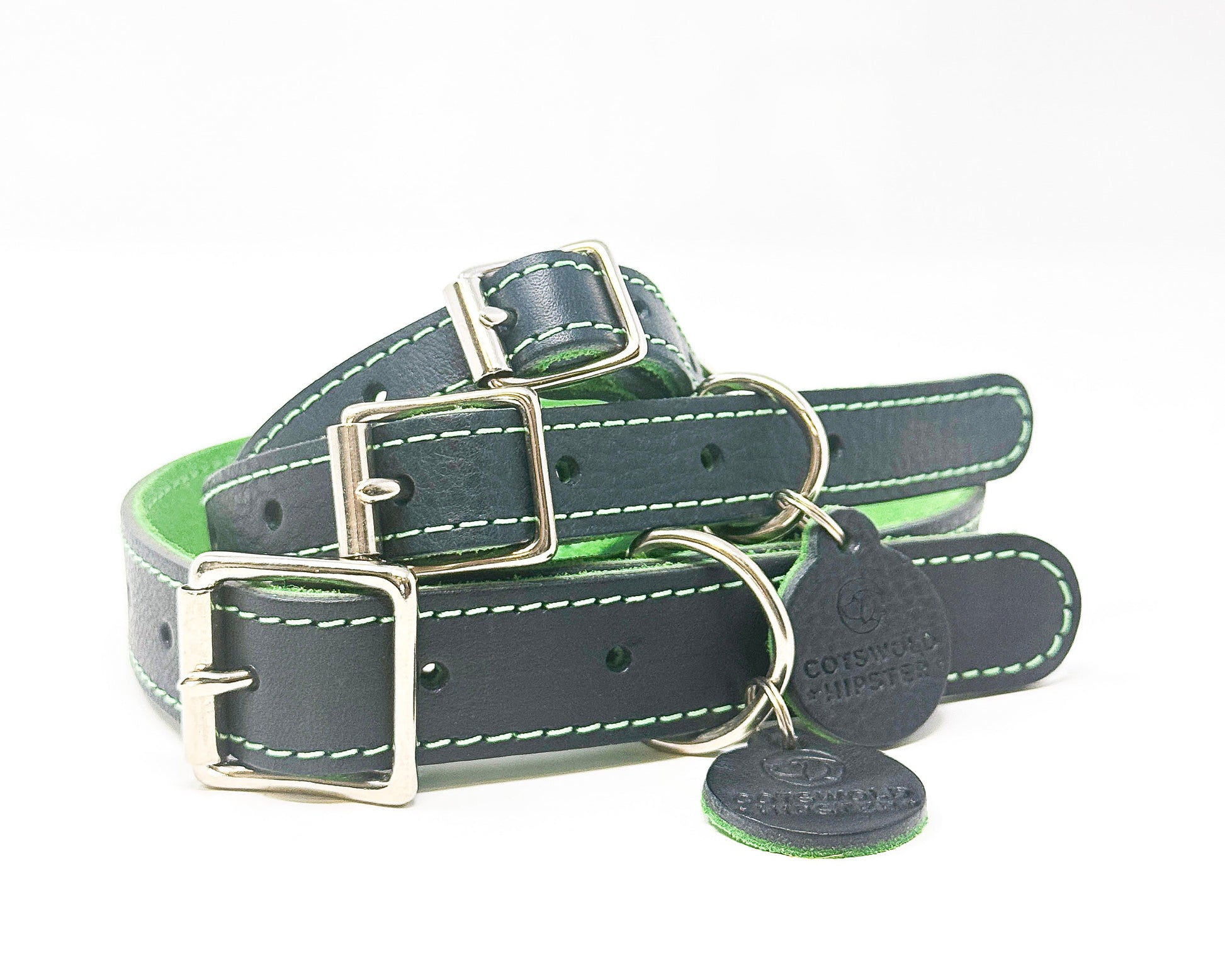 Stack of three handmade navy leather dog collars with emerald green suede backing from the Summer Fair Collection