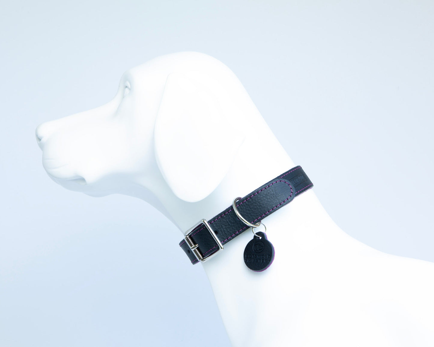Handmade navy leather dog collar with fuchsia suede lining on white dog mannequin side view