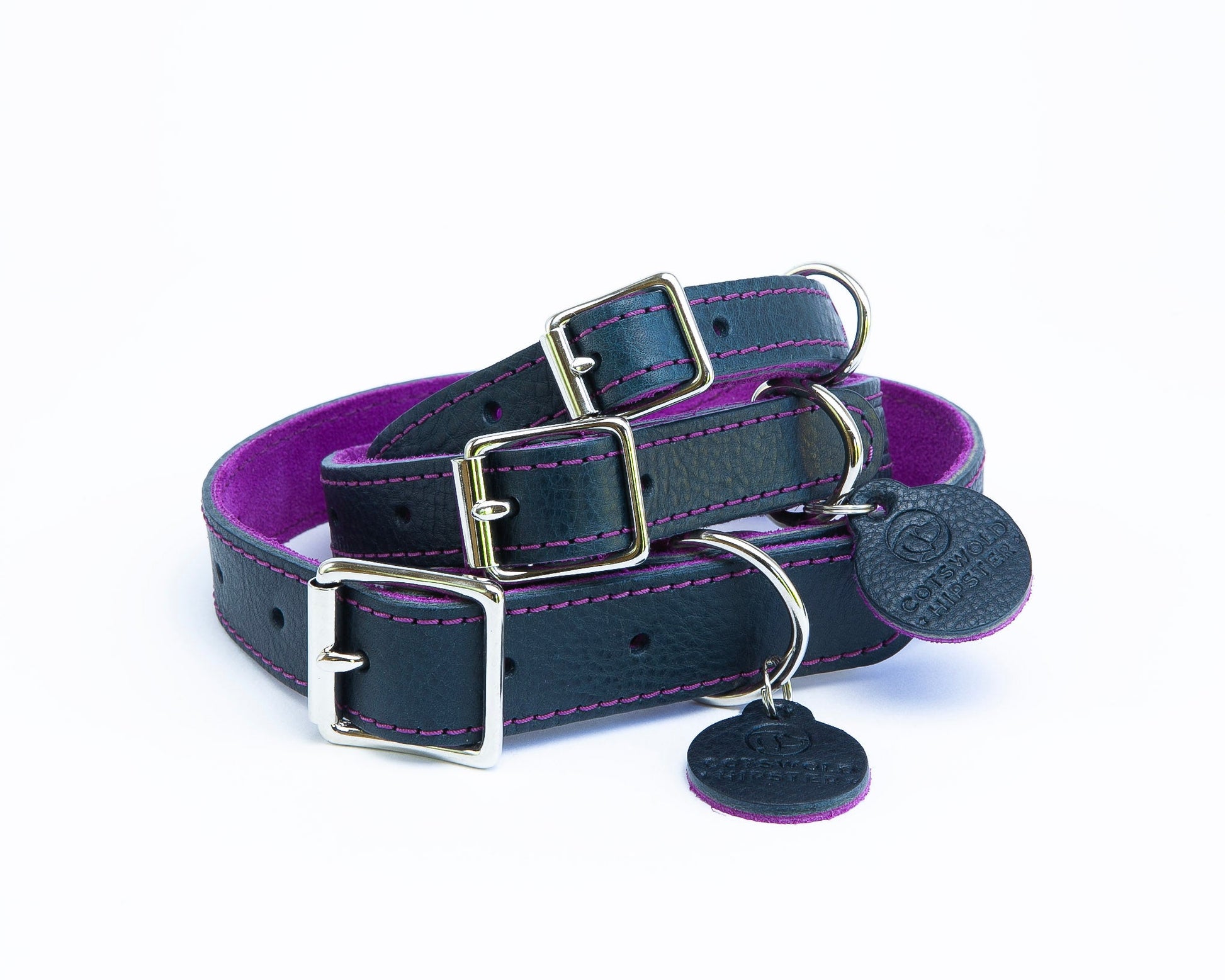 Stack of three handmade navy leather dog collars with fuchsia suede backing from the Summer Fair Collection