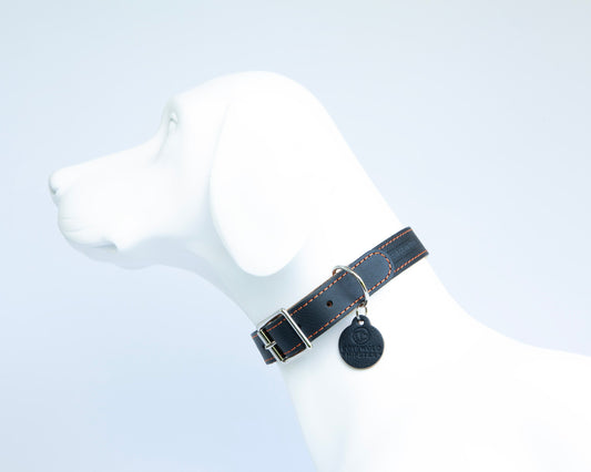 Handmade navy leather dog collar with tangerine suede lining on white dog mannequin side view