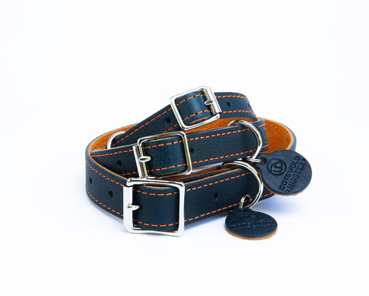 Stack of three handmade navy leather dog collars with tangerine suede backing from the Summer Fair Collection