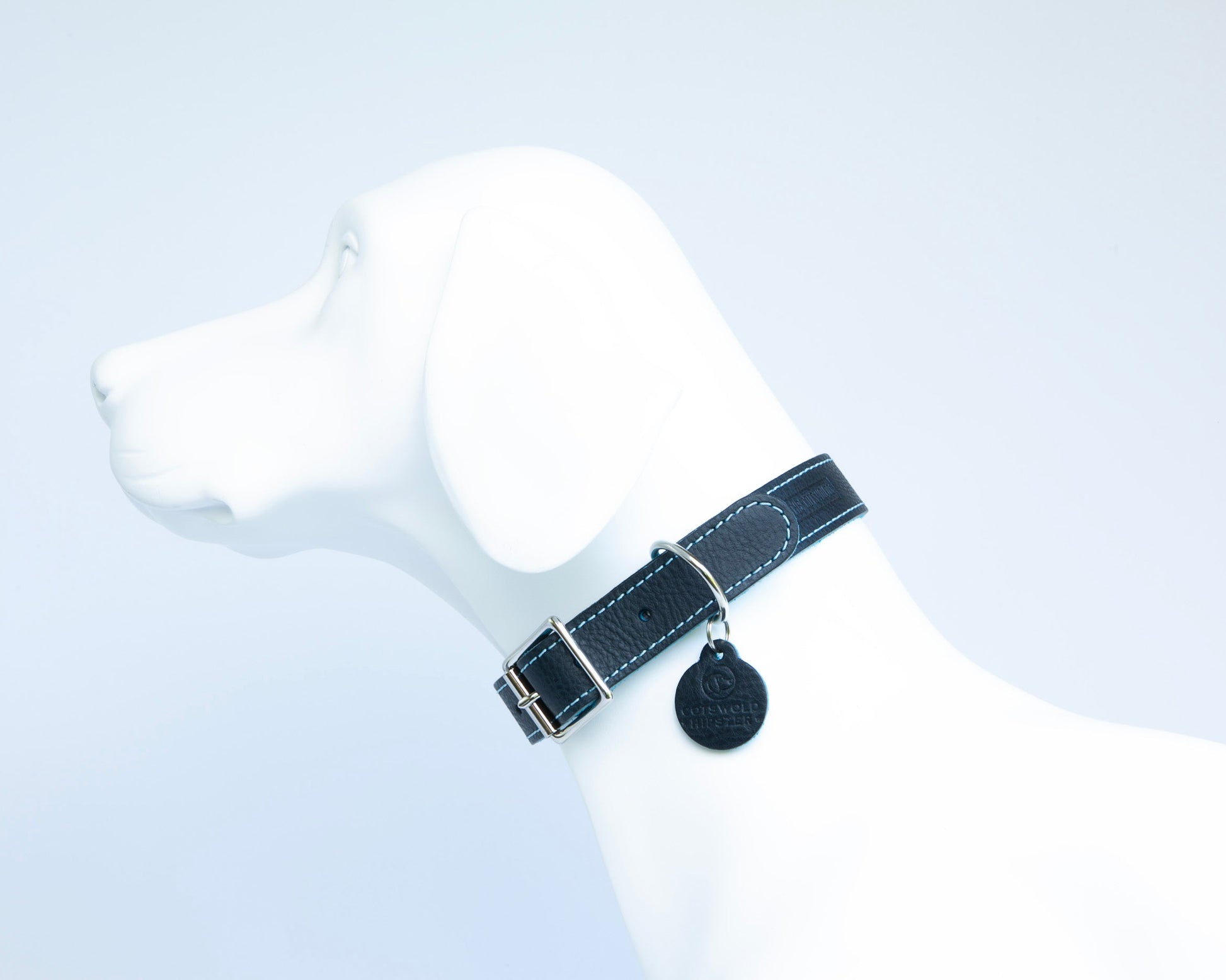 Handmade navy leather dog collar with turquoise suede lining on white dog mannequin side view