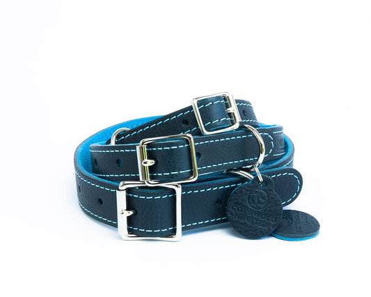 Stack of three handmade navy leather dog collars with turquoise suede backing from the Summer Fair Collection