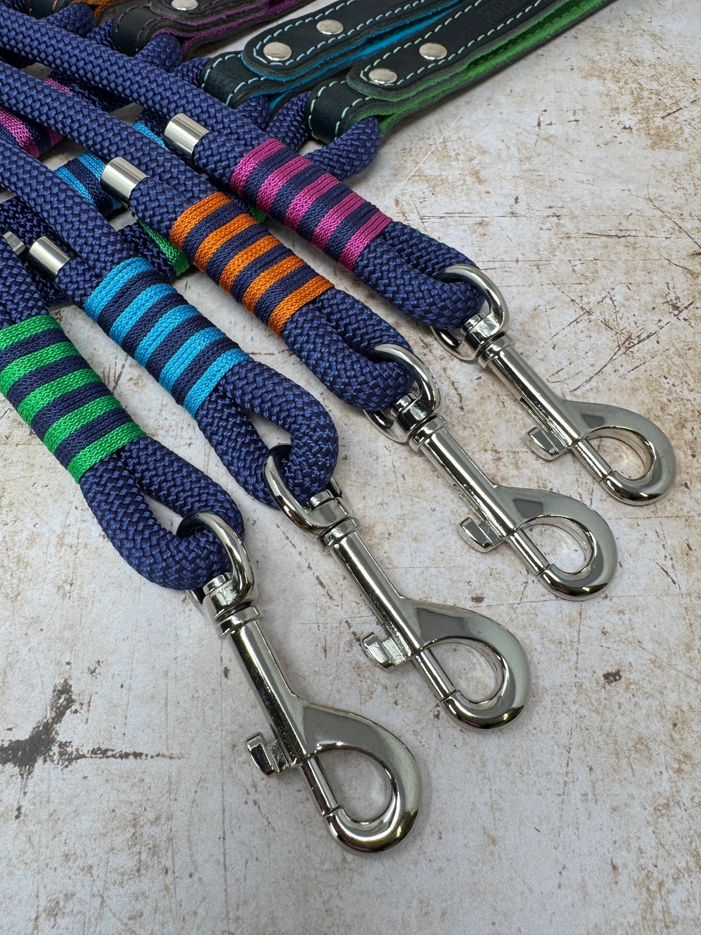 Close-up of trigger clip and signature stripe whipping detail on handmade leather and rope dog leads from the Summer Fair Collection