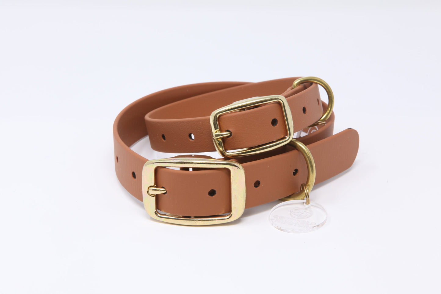 Stack of tan Biothane dog collars with brass hardware in multiple sizes, handmade by Cotswold Hipster 